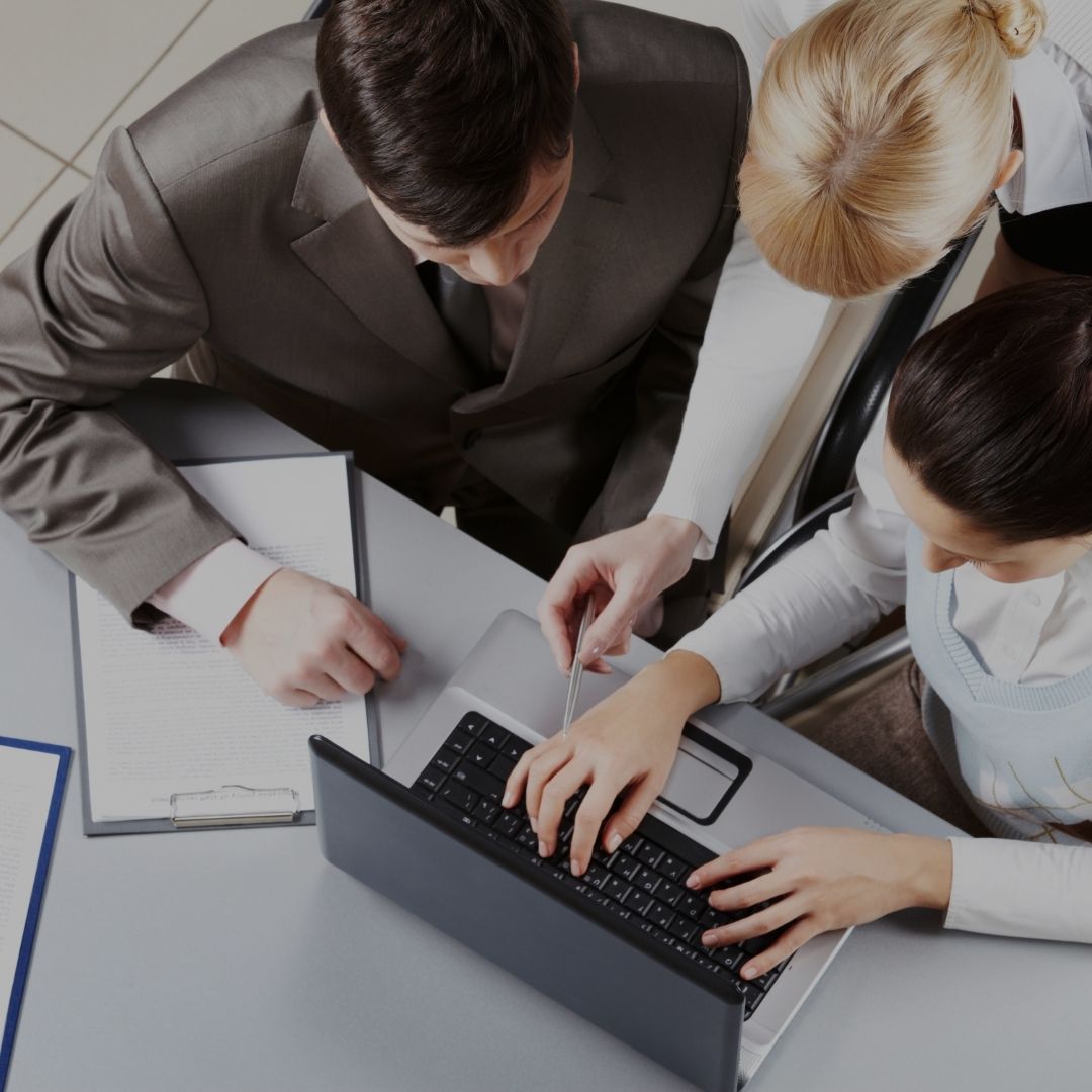 three business people looking at a laptop