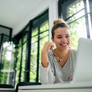 a smiling woman looking at a computer