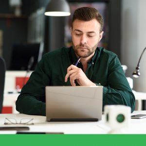 Man working on a laptop in an office.