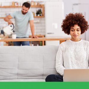 Smiling woman using a laptop in her home.