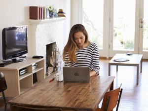 Image of a woman scrolling on her laptop