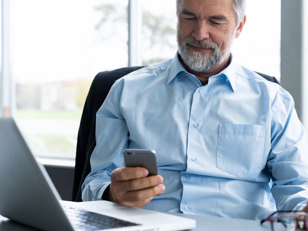 Image of a man scrolling on his cell phone