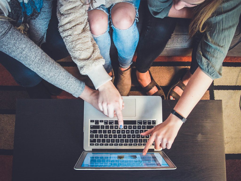 young group sharing a computer screen